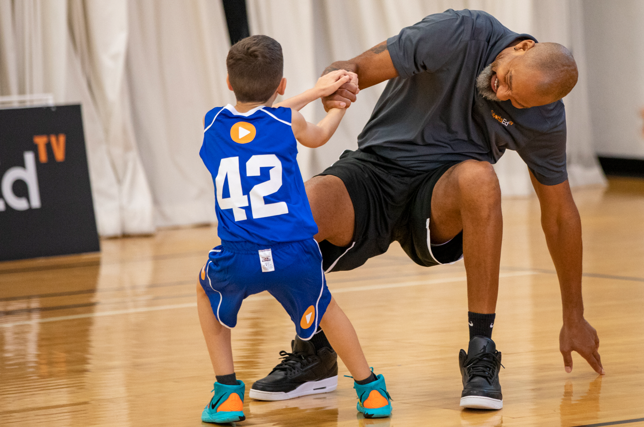 Mark Strickland helping a young kid in basketball