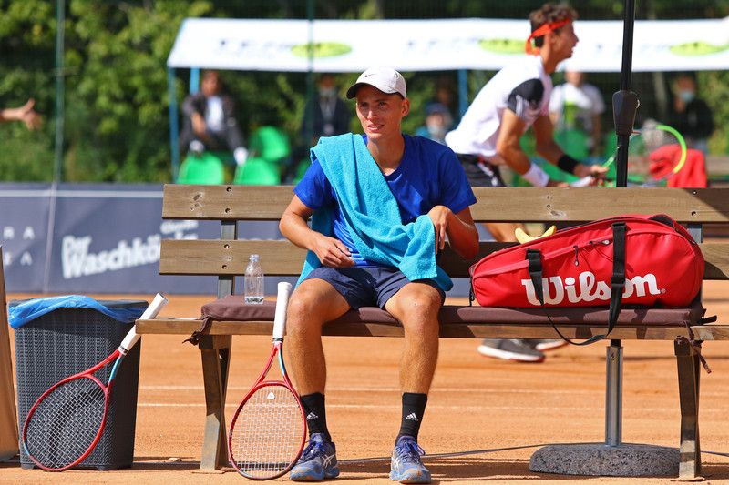 Tennis player in between points on a bench