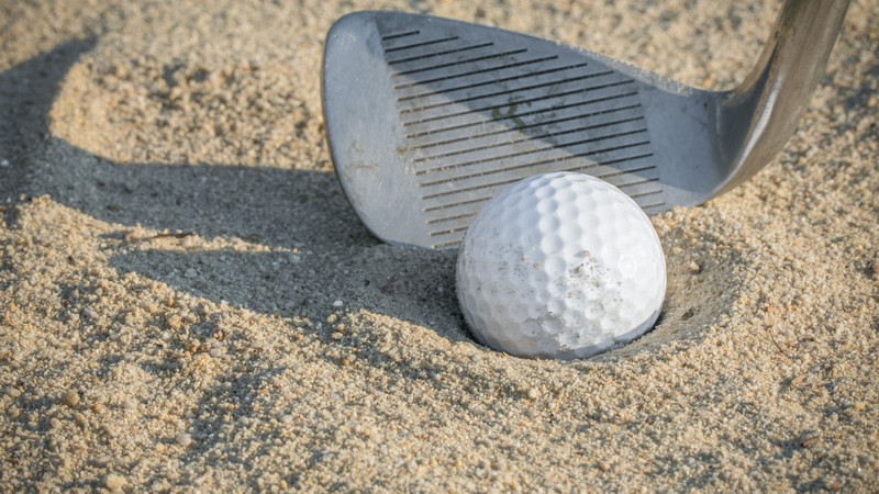 Close up Golf Ball in Sand Trap with Pitching Wedge 2
