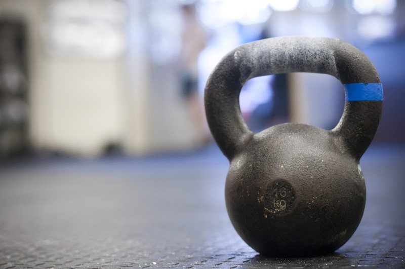 Black Kettlebell with chalk handprint on Gym Floor Black Kettlebell with chalk handprint on Gym Floor